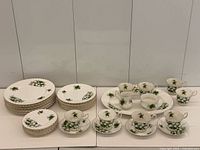 Full set displayed: stacked plates, platter, cups, saucers, creamer, sugar