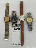 Group shot of four wristwatches on white background