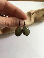Front view of both teardrop agate earrings held by hand