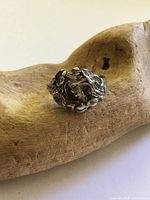 Front view of sculptural sterling ring showing female face and hair details