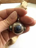 Front view of sterling silver orb pendant with blue cabochon, bail visible