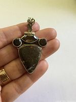 Front view of sterling silver agate pendant in hand