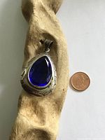 Front view of sterling silver pendant beside coin for scale