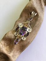 Front view of sterling silver pendant showing all stones and scroll design