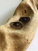 Both earrings front view on wood prop