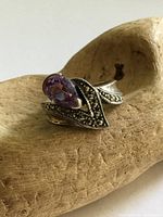Front view of sterling silver ring showing amethyst and marcasite swirl design