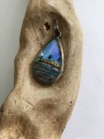 Front view showing iridescent butterfly wing image, silver bezel, bail