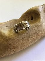 Full view of sterling silver VW Bug ring on driftwood
