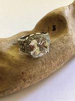 Front view of sterling silver ring showing large clear solitaire and rhinestone shoulders