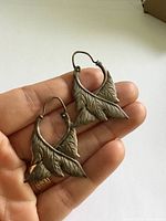 Front view of both sterling silver leaf earrings in hand