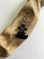 Front view of sterling silver pendant with onyx and garnet stones