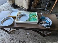 All items laid out on table: four glass tumblers, casserole dish, two pie pans, grill pan, serving tray
