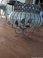 Full view of bubble glass bowl in metal frame and stand