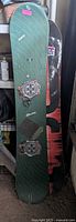 Front view of green K2 Electra snowboard with Torsten board behind