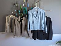 Five jackets hanging: beige, grey tweed, blue leather, black RQT