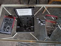 Three primary items on glass table: Autocraft flaring tool set, Duofone answering machine, Husky wrench set with scissors beside