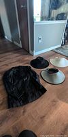 Group shot of black leather jacket and three hats arranged on floor