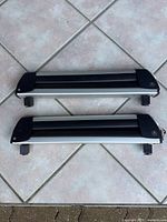 Two Acura ski roof rack attachments laying flat