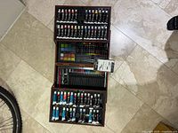 Closed overview of tri-level wooden Art101 art kit fully opened on floor