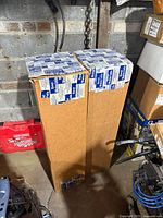 Two tall cardboard boxes with fibreglass roofing roll labels