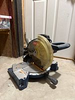 Left-front view of Ryobi compound miter saw showing blade guard and base