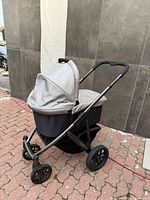 Stroller frame with bassinet attached, visible basket underneath