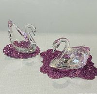 Pair of Swarovski crystal swans on purple pads