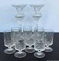 All ten glass pieces grouped, candle holders behind shot glasses