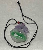 Front view of jadeite dragon pendant on black cord