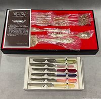 Open Royal Sealy box showing gold-plated utensils in red tray and open Ideal Sucut knife tray beneath