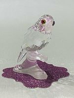 Front three-quarter view of crystal parrot on stand