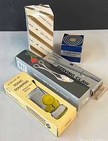 All boxed items grouped: striped box, pastry tongs box, serving claw box, tonic stampers box, Marksman box