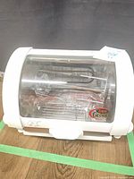 Front view of Baby George Foreman rotisserie oven showing spit rod inside