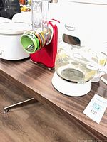 Electric grater-slicer side view showing coloured drums and feed tube