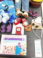 Assorted shoes, accessories, sticker sheet and wristbands with lower portion of doll legs