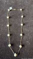 Full view of necklace laid flat showing pearl spacing and clasp