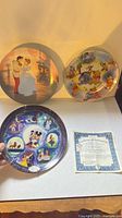 Front view of three Disney collector plates with certificate visible