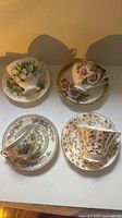 Four cup and saucer sets displayed