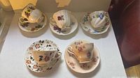 All five cup and saucer sets displayed