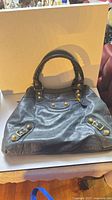 Full view of blue leather handbag front