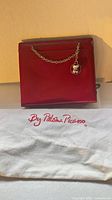 front view of red handbag with chain and dust bag