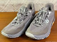 Three-quarter front view of both shoes showing uppers, laces, logos, and Vibram sole edge