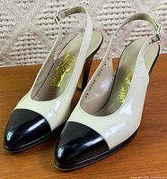 Front and side view of both slingback pumps showing two-tone design