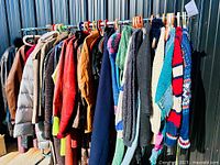 Full rack of assorted jackets, coats and sweaters outdoors