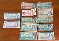 All 12 Canadian banknotes laid out by denomination