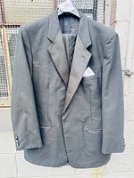 Full view of black tuxedo jacket on hanger