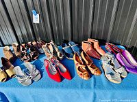 Full lot of approximately 12 pairs of women’s shoes displayed on blue cloth