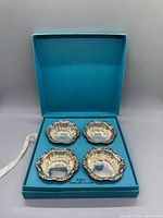 open Birks box showing four sterling nut dishes