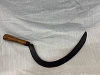 Full view of sickle front showing blade curve and handle