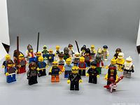 Front view of all 32 LEGO minifigures arranged in rows with accessories visible